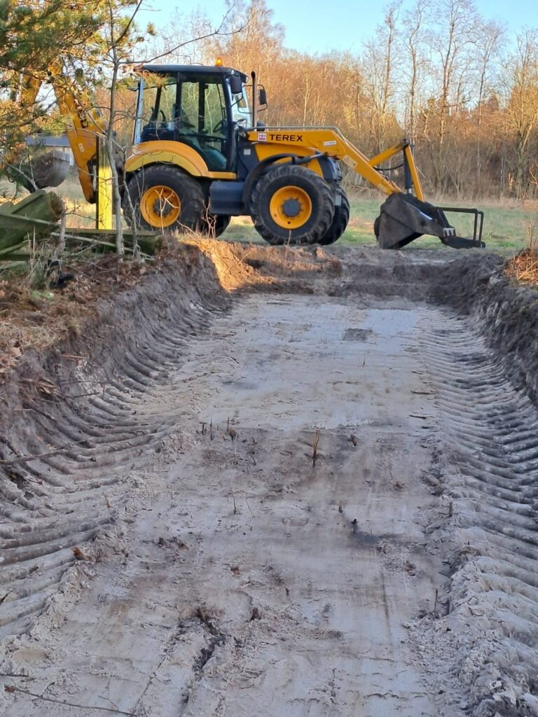 Gravemaskine arbejder på jordbyggeri i naturen