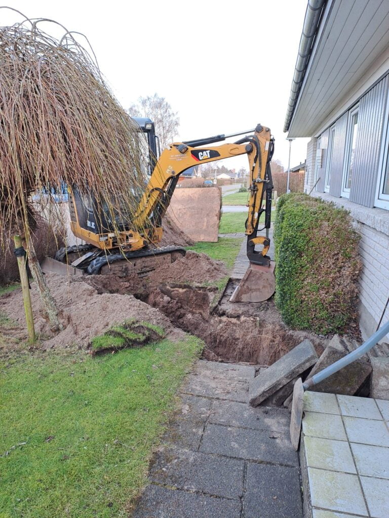 Gravemaskine graver ved husets fundament