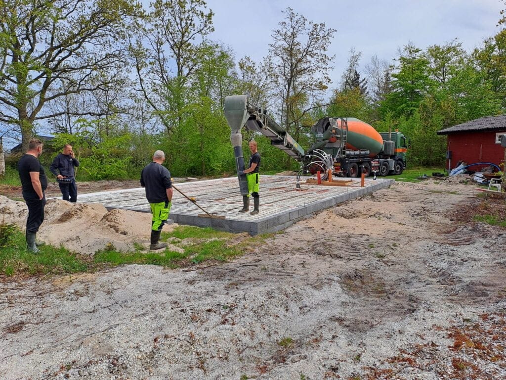Arbejder hælder beton til husfundament