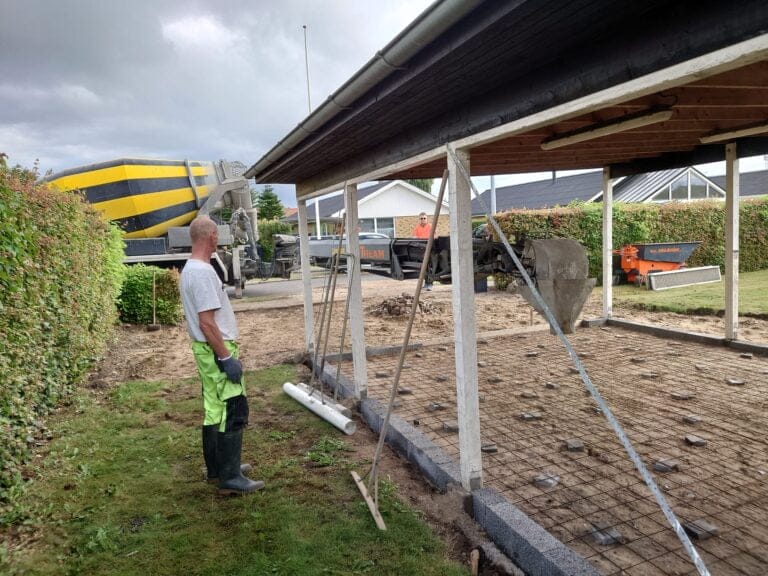 Arbejder forbereder betonfundament til garagebygning